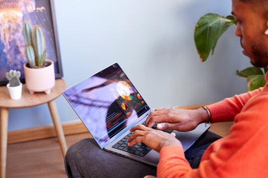 Cropped image of black male designer working on laptop