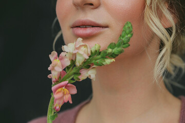 Anonymous woman smelling flowers