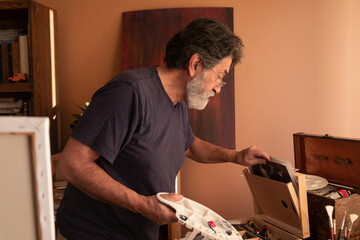 Retired latin man painting at home