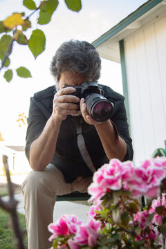 Retired latin man shooting photos in his garden
