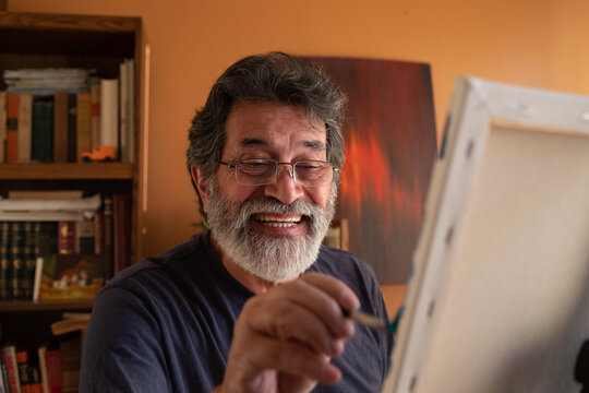 Retired latin man painting at home