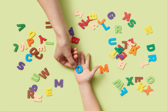 Paper letter O being given from mother to child's hands.