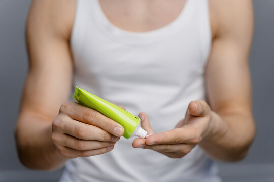 Women's hands squeeze cream out of a tube