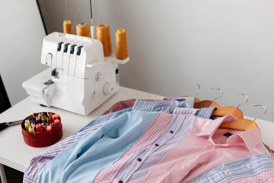 Freshly made handmade shirts sewing machine composition on table