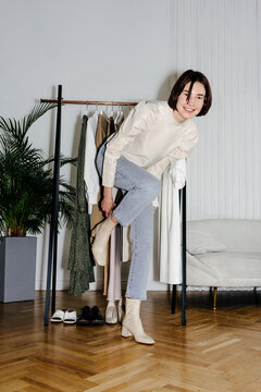 Woman putting on boots in studio
