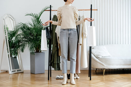 Crop woman standing with packages in studio
