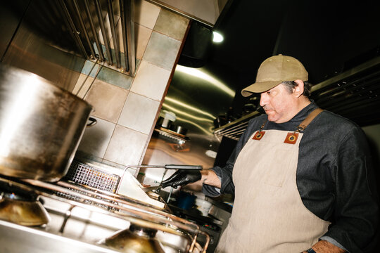 Cook working in kitchen of fast food cafe