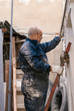 Senior worker standing on truck folding stairs