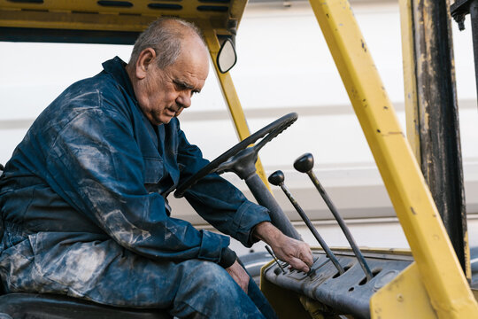 Male worker operating cargo with control stick