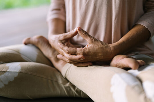 Close up image of hands of a woman meditating and holding mudras