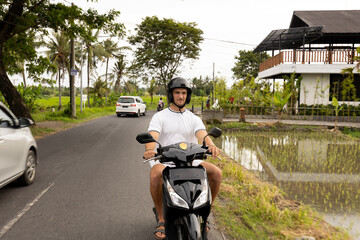 Tourist man riding a scooter on the roads of Southeast Asia