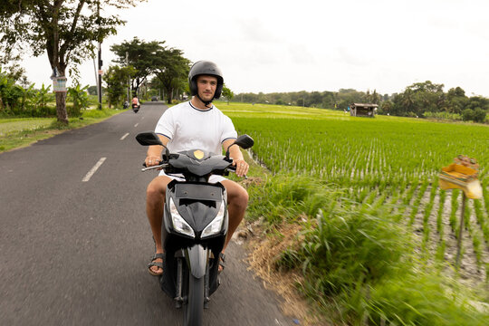 Lifestyle image of a man driving motorbike in Bali  
