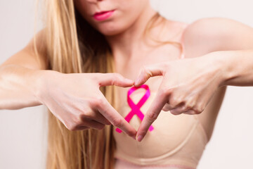 Woman with pink cancer ribbon on breast