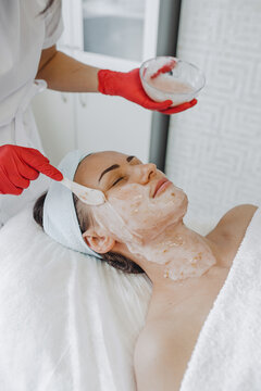 Applying alginate mask on face in salon 