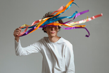 Young LGBT activist holding multicolored ribbons