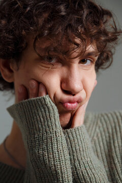 Unhappy guy pouting lips and touching cheeks