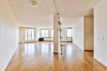 an empty living room with wood flooring and white walls in the center of the room is a large window