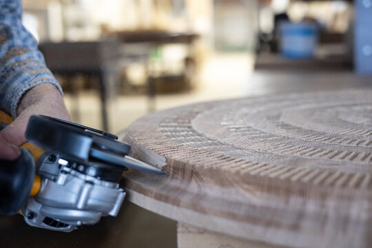 Manufactory of a table in wood by an artist in his atelier 
