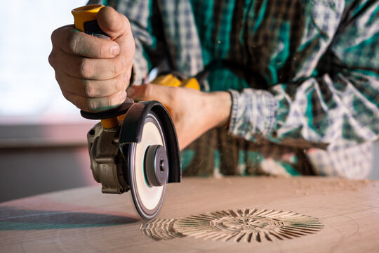 Close Up Of A Worker Holding A Mini Chainsaw Drawing Patterns On Wood 