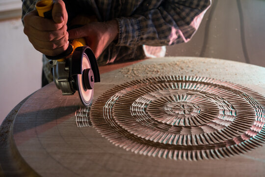 Manufactory of a table in wood by an artist in his atelier 