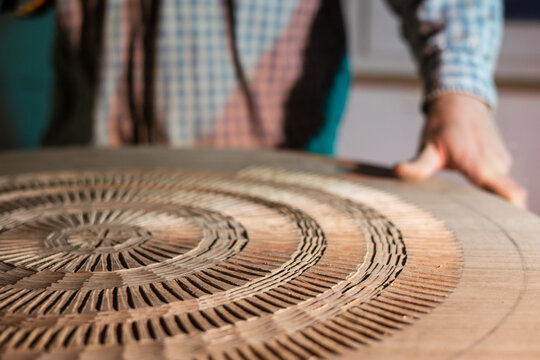Man flip a round table with his hand during the creation process