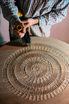Upper view of Artist carving wood and observing his art-piece 