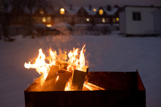 light the wood fire for the barbecue during a cold winter snowy day