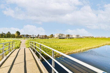 a bridge over a body of water with buildings in the background and grass on both sides, as well for boats to pass by