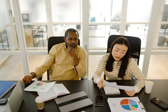Busy manager group analyzing charts data 
