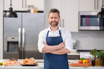 man cook seafood. man cook seafood in apron. man cook seafood in the kitchen. photo of man cook delicacy seafood