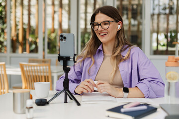 Happy woman recording video in coworking