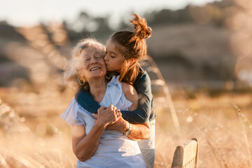 Grandmother carrying her loving grandson at field