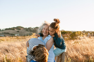 Grandmother and grandchildren embraced in nature