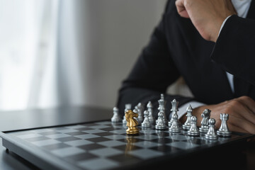 Investor playing chess board game conceptual image of businessman holding chess piece in business...