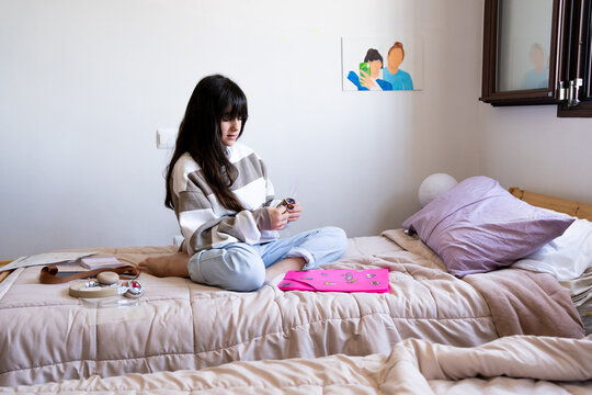 Preteen girl decorating her school folder in her bedroom