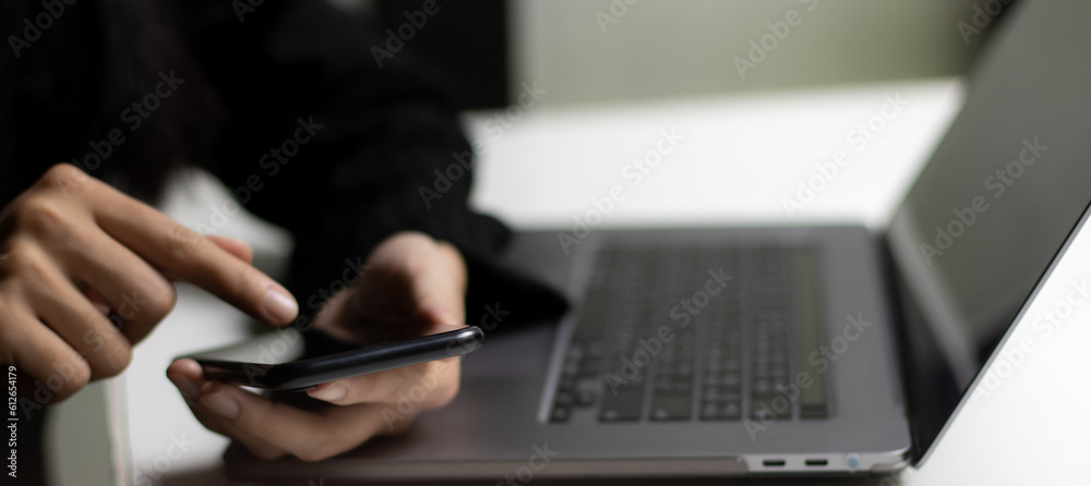 Poster close up using smartphone and laptop computer with blank screen . tachnology and business concept