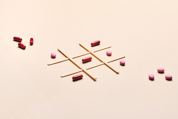 pills and capsules on a tic tac toe game