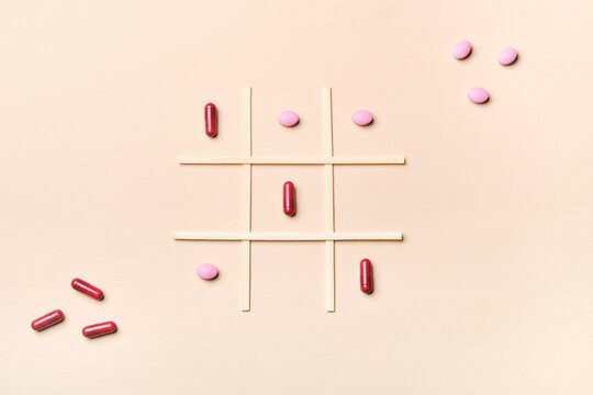 pills and capsules on a tic tac toe