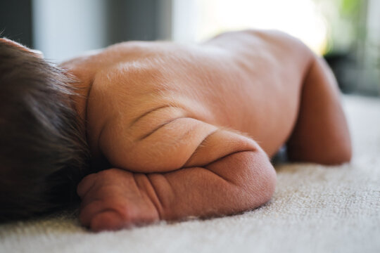 Detail of newborn baby wrinkles and hair.