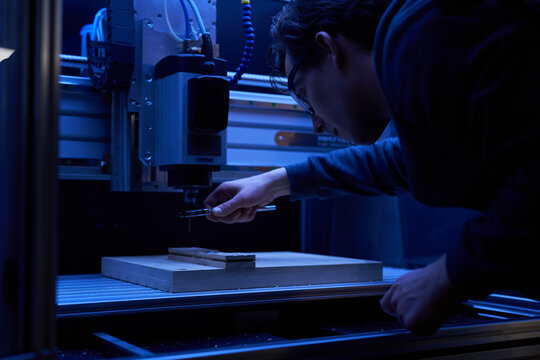 A man operating a computer numerical control machine