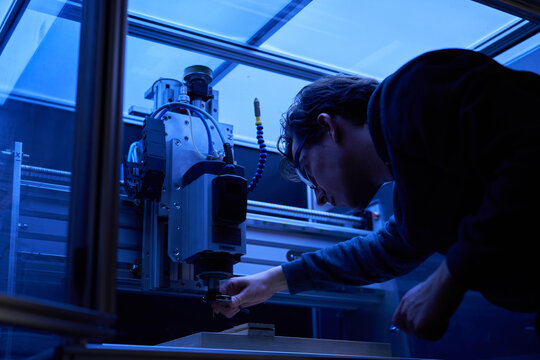 A man operating a computer numerical control machine