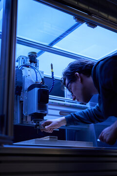 A man operating a computer numerical control machine