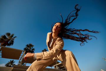 Young lady listening to song and dancing in park