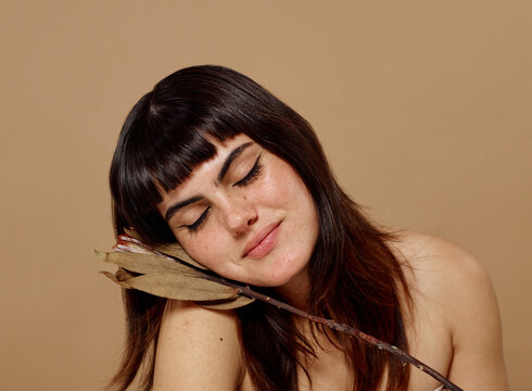Woman with soft smile and closed eyes: self-care concept
