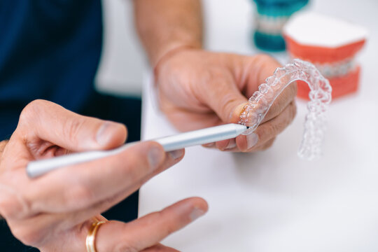 Dentist holding transparent braces