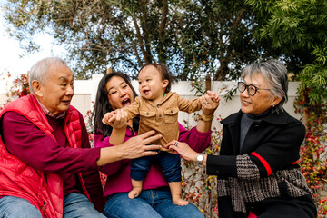 Happy and smiling multi generational asian family outdoors in yard