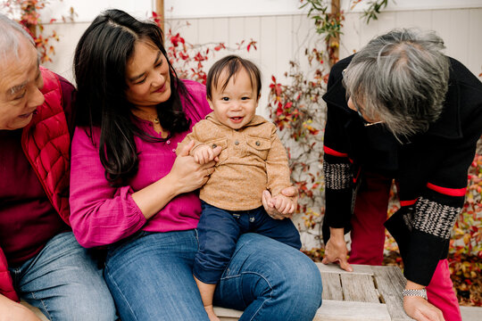 Happy and smiling multi generational asian family outdoors in yard