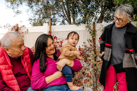 Happy and smiling multi generational asian family outdoors in yard
