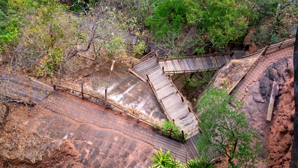 Looking down below Phu Thok, you can see the winding pathway and a wooden bridge that alternates,...