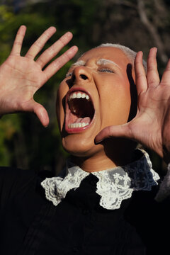 A Gothic Woman with Shaved White Hair and a Black Dress and screaming